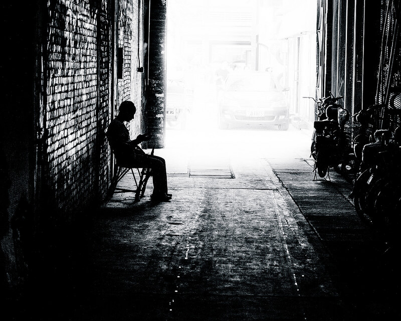 old man sitting in corridor