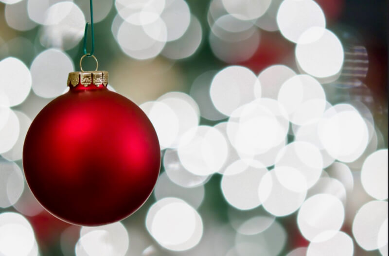 Julie Rideout - Red Ornament with Christmas Tree Bokeh